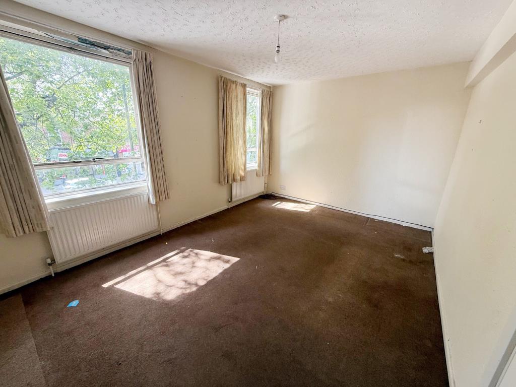 Lot: 109 - FIRST AND SECOND FLOOR THREE-BEDROOM MAISONETTE - Living room with two windows with views onto street